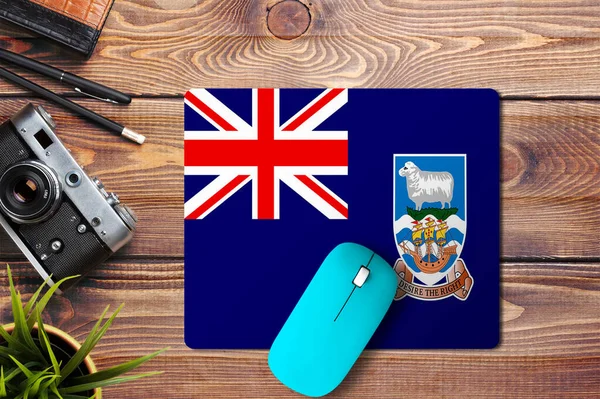 福克兰群岛的木制背景旗 蓝色无线鼠标在鼠标垫上 顶部视图 数字媒体概念 — 图库照片