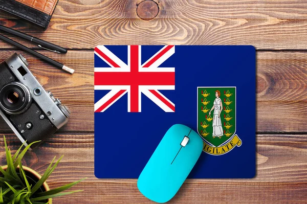 英属维尔京群岛在木制背景上的旗帜 蓝色无线鼠标在鼠标垫上 顶部视图 数字媒体概念 — 图库照片