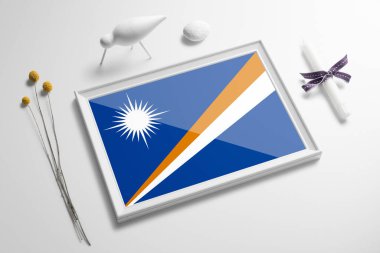 Marshall Adaları bayrağı ahşap çerçevede masanın üstünde. Beyaz doğal yumuşak konsept, ulusal kutlama teması.