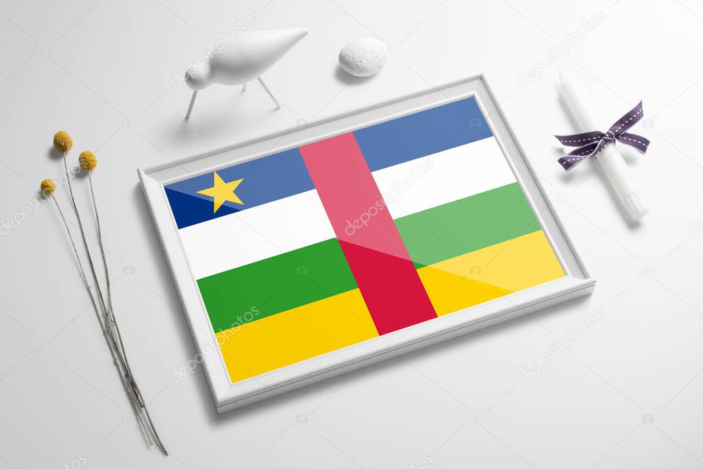 Central African Republic flag in wooden frame on table. White natural soft concept, national celebration theme.