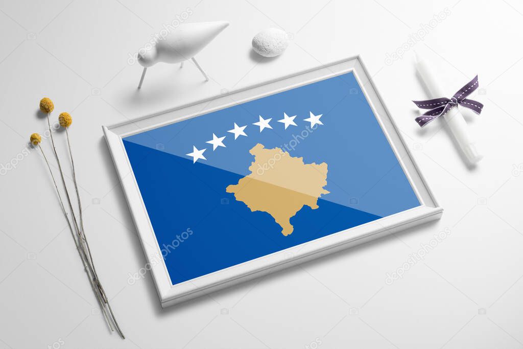 Kosovo flag in wooden frame on table. White natural soft concept, national celebration theme.