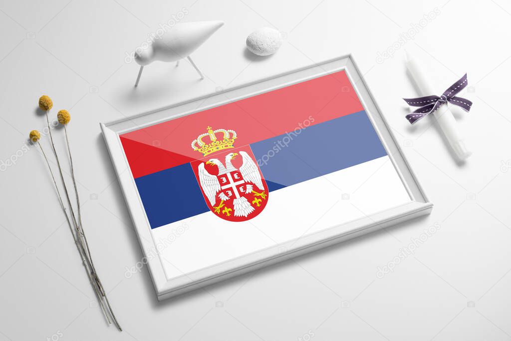Serbia flag in wooden frame on table. White natural soft concept, national celebration theme.