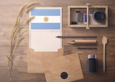 Arjantin daveti, kutlama mektubu konsepti. El işi kâğıdı ve zarflı bayrak. Bölme, mürekkep, tahta kalem nesneleri ile geçmişe dönük tema.