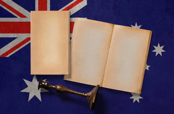Australia vintage historical concept. Retro craft papers and old wooden candlestick on national flag wall background.