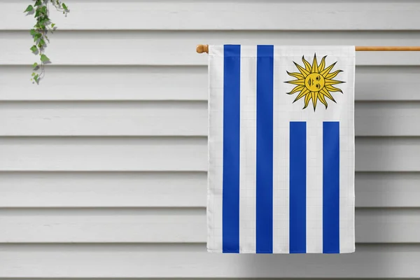 ウルグアイの国旗は田舎町の木製の壁に沿って柵から吊るされている 独立記念日の概念 — ストック写真