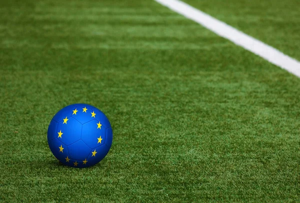 European Union flag on ball at soccer field background. National football theme on green grass. Sports competition concept.