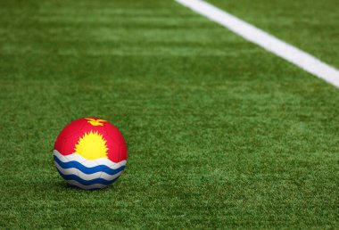 Futbol sahasında top üzerinde Kiribati bayrağı. Ulusal futbol teması yeşil çimlerde. Spor yarışması konsepti.