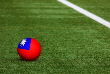 Futbol sahasında top Tayvan bayrağında. Ulusal futbol teması yeşil çimlerde. Spor yarışması konsepti.