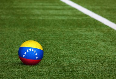 Futbol sahasında top Venezuela bayrağında. Ulusal futbol teması yeşil çimlerde. Spor yarışması konsepti.