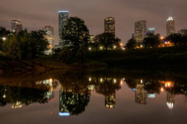 Buffalo Bayou geceleri yansıtan Houston, Texas manzarası.