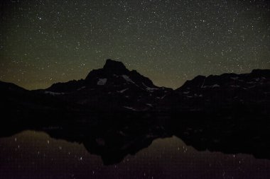 Banner Peak and stars reflecting on Thousand Island Lake at night, Ansel Adams Wilderness, California. clipart