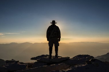 A self portrait of a hiker eclipsing the sun at sunrise on the peak of Mt. Whitney after completing the John Muir Trail, August 20, 2017.