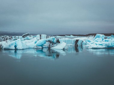 İzlanda 'daki Jokullsarlon Körfezi dramatik bulutlarla dolu buzul parçalarıyla dolu.