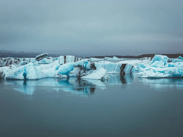 İzlanda 'daki Jokullsarlon Körfezi dramatik bulutlarla dolu buzul parçalarıyla dolu.