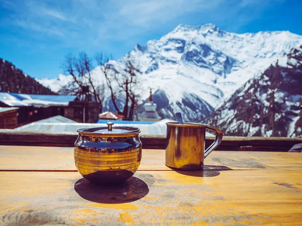 Sabah keyfine bak, arka planda Himalaya sıradağlarıyla paslanmaz bir fincan çay ve doz.