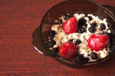 Yulaf ezmesi meyve bir çocuk yiyor. Bir tabak yulaf ezmesi. Bir tabak holding eller. Kahvaltıda meyve. Sağlıklı gıda.