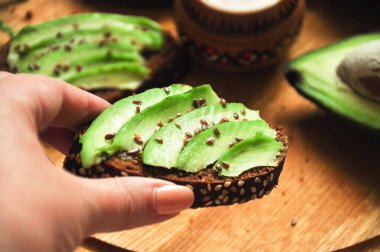 Avokado ile el tost. Sağlıklı kahvaltı. Diyet çerez. Ahşap oyun tahtası çavdar ekmeği. Ev yapımı yemek. Hızlı kalori Gıda.
