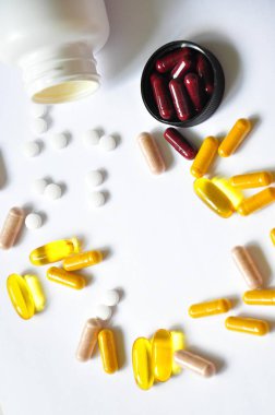 Tablet masanın üzerinde. Beyaz arka plan ile tıp. Yemek tarifleri tabletleri. Farklı vitaminler. Renk hap.