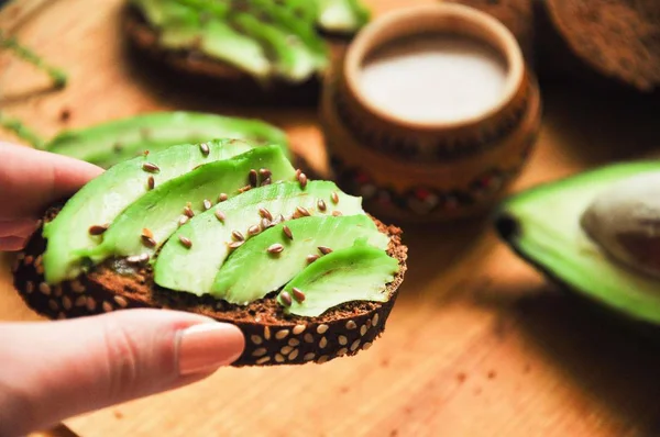 Rostat Med Avokado Hand Hälsosam Frukost Dietary Mellanmål Rågbröd Träskiva — Stockfoto