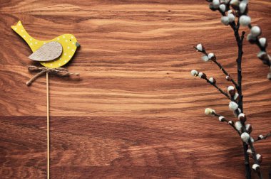 Söğüt dalları üzerinde sarı bir kuş. Paskalya topper. Bahar tatil ruh hali. Ahşap arka plan. Rustik tarzı.