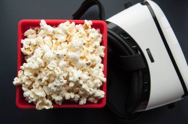 Beyaz ve siyah arka plan üzerinde kırmızı bir kap içinde patlamış mısır. Film için aperatifler.