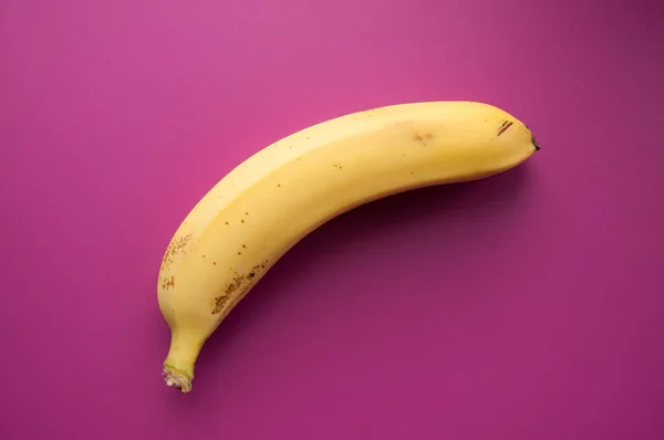 Yellow ripe banana on a pink background