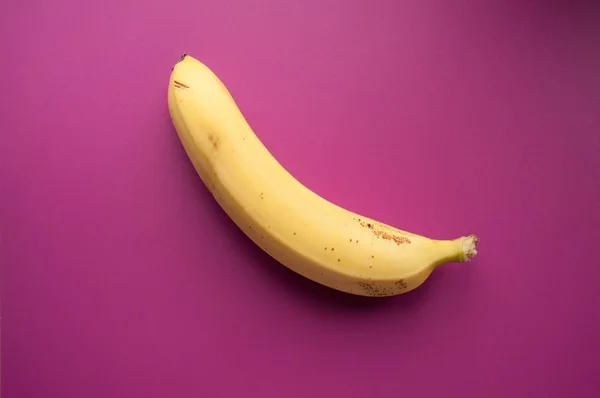 Yellow ripe banana on a pink background