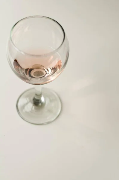 Transparent glass of wine. Pink wine. Festive mood. Alcohol for a group of friends. Delicious drink. Light background. Noble drink. Lavender and rose wine. Wine from lavender — Stock Photo, Image