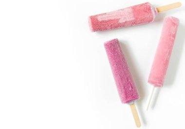 Pembe bir arka plan üzerinde bir sopa üzerinde parlak meyve dondurma. Donmuş meyve buzu. Yaz havası. Sıcak havalarda tatlı soğutma. Çocuklar için en sevdiği lezzet. Ev yapımı ahududu, çilek, karpuz buz