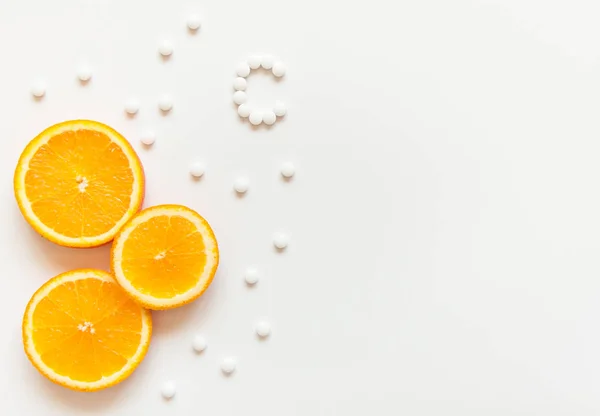 Slices of orange on a white background. Fruit with vitamins. Tablets with vitamin C against colds. Exotic tropical fruit for juice. Orange food. Meals for vegans.