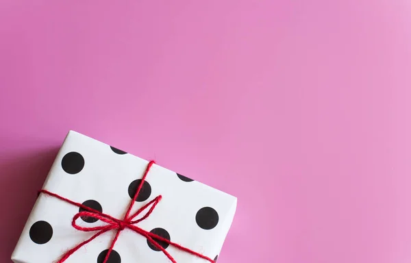 Envoltura de regalo. Regalos embalados, cajas de papel blanco con lunares negros, papel para regalos, sobre un fondo rosa. Regalos para San Valentín, Cumpleaños, Día de la Madre. Preparación para el envoltorio de regalo. Paquete —  Fotos de Stock
