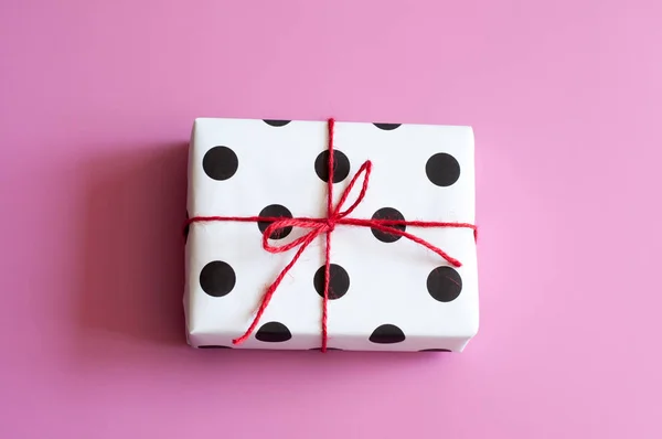 Envoltura de regalo. Regalos embalados, cajas de papel blanco con lunares negros, papel para regalos, sobre un fondo rosa. Regalos para San Valentín, Cumpleaños, Día de la Madre. Preparación para el envoltorio de regalo. Paquete —  Fotos de Stock