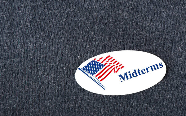 Крупный план наклейки с американским флагом и словом "промежуточные экзамены" на рубашке ВМФ
.