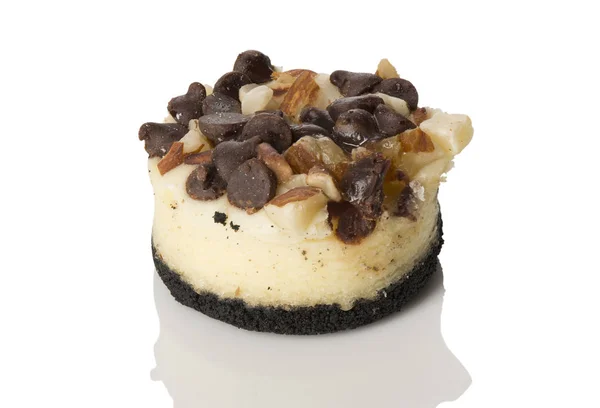 Bir Mini Cheesecake ile çikolata cips ve somunları, beyaz yansıması ile açılı