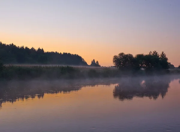 Foggy sunrise on the river Svisloch. Orange sunrise in Belarus