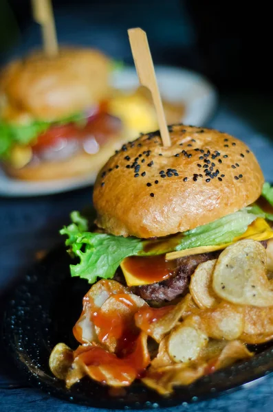 Siyah susam ve yangınlar rustik hamburger ahşap bir masa bir restoranda servis