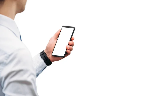 A business man in a shirt holds a phone with a white screen on a white background. Narrow panoramic photo with a place for an inscription. Photo for the designer. Isolate the photo. Clock on the hand.