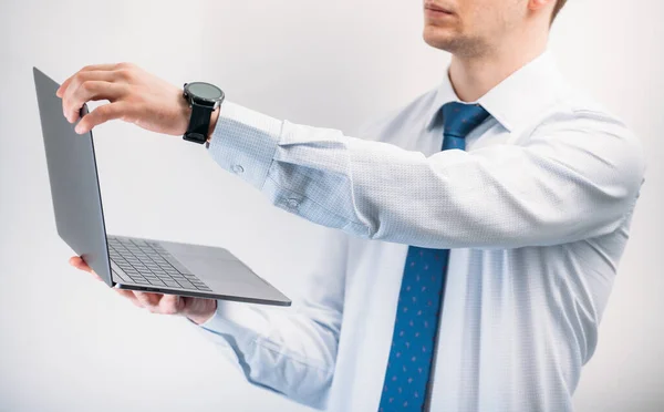 一个穿衬衫的男人站在白色的背景上 拿着笔记本电脑 一个男人看着手提电脑的屏幕 关于视频交流的对话 — 图库照片