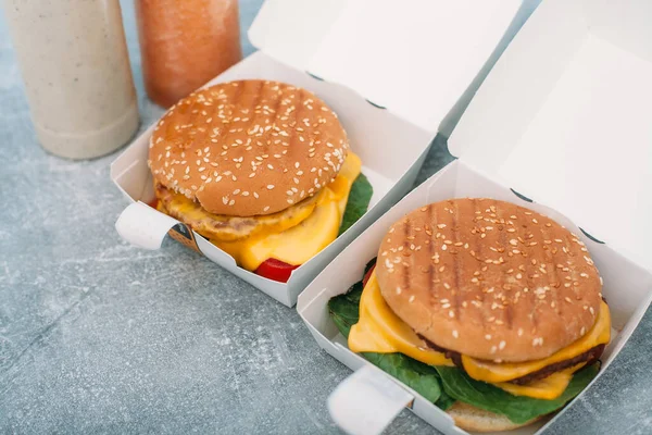 Vegan burgers in a paper box with food delivery.Natural juice on the background.