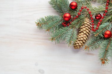 Beyaz ahşap zemin ve kırmızı topları bir şiş ile Noel ağacı dalı