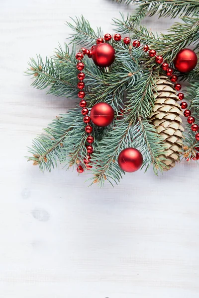 Beyaz ahşap zemin ve kırmızı topları bir şiş ile Noel ağacı dalı