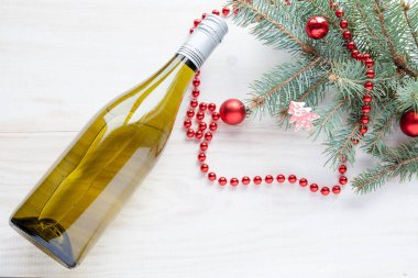 şişe şarap yakınındaki Beyaz ahşap zemin üzerinde Noel ağacı Yılbaşı oyuncakları