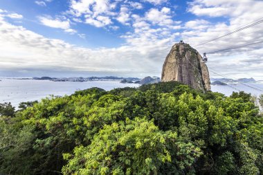 Gösterim Sugar Loaf Dağı ve Rio Janeiro şehri, varoşlarda ve favelas, koyları, Adaları, plaj ve üst şehir manzarası muhteşem manzarasına teleferik üzerinde giderken bulutlu bir günde yapmak