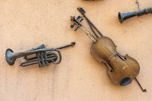 レトロなスタイルの楽器 バイオリンと昔歴史の周りに私たちを運ぶ古いトランペットの音楽ヴィンテージ ビューの壁からぶら下がっています — ストック写真