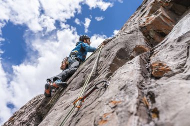 The last movements to reach the summit by a male climber. Rock climbing inside Andes mountains and valleys at Cajon del Maipo, an amazing place to enjoy rock climbing and mountaineering sports, Chile clipart