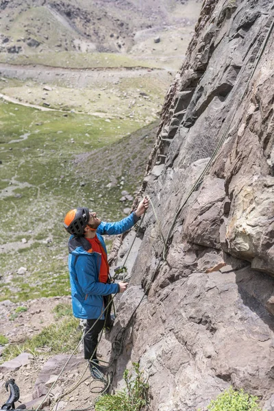 一名男子在安装路线后用绳子工作 爬上了路线 以便在智利圣地亚哥安第斯山脉中心山内的攀岩墙上保护第二个登山者 — 图库照片