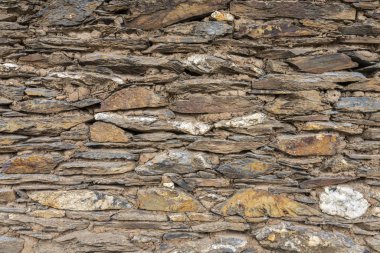 Bir taş dokulu deseni bir tuğla gibi kayaların arasında bazı flora başladığı büyümeye kendi alan mükemmel uyan başka bir yere duvar. Şili kırsal, Cobquecura, Şili için bir şehir duvar