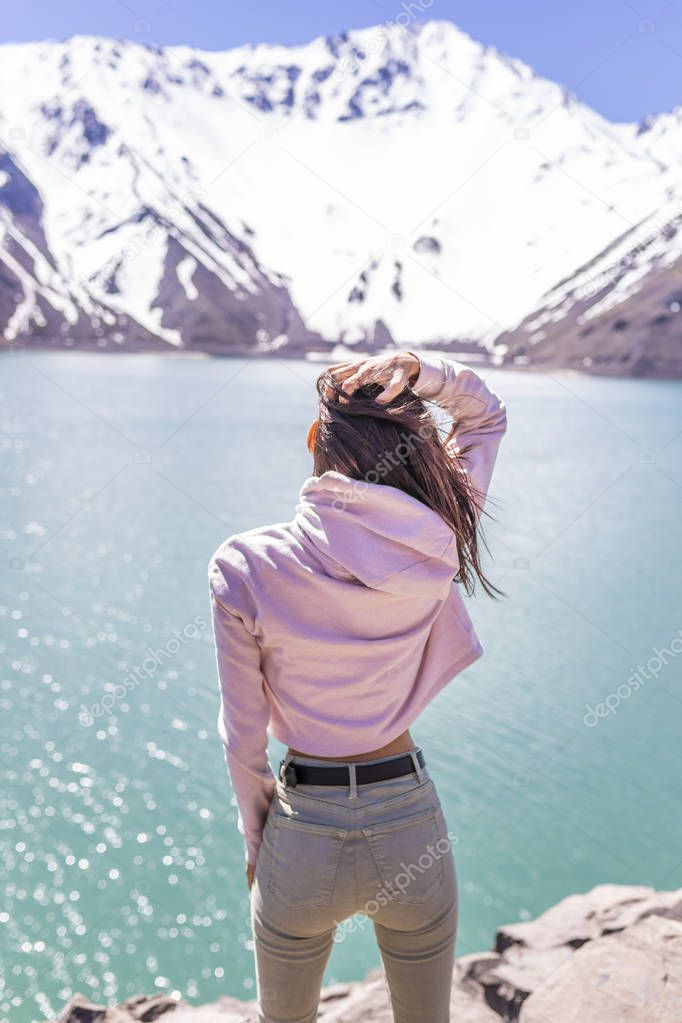 Girl looking at the amazing mountain view. with messy windy hair Turquoise waters of 