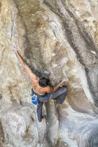 The last movements to reach the summit by a male climber. Rock climbing inside the Andes mountains at Cajon del Maipo, Chile. Climber solving the movements of \