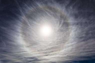 Güneş 'in etrafında ışık kırılması sonucu oluşan muhteşem bir ışık halkası. Troposferdeki üst atmosfer katmanlarındaki buz kristalleri bu dairesel güneş halesini oluşturuyor.